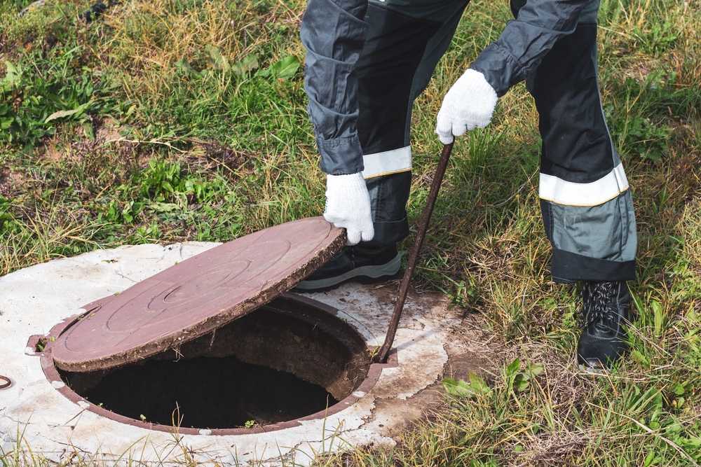 On,A,Septic,Sewer,Well,,A,Worker,Opens,The,Manhole